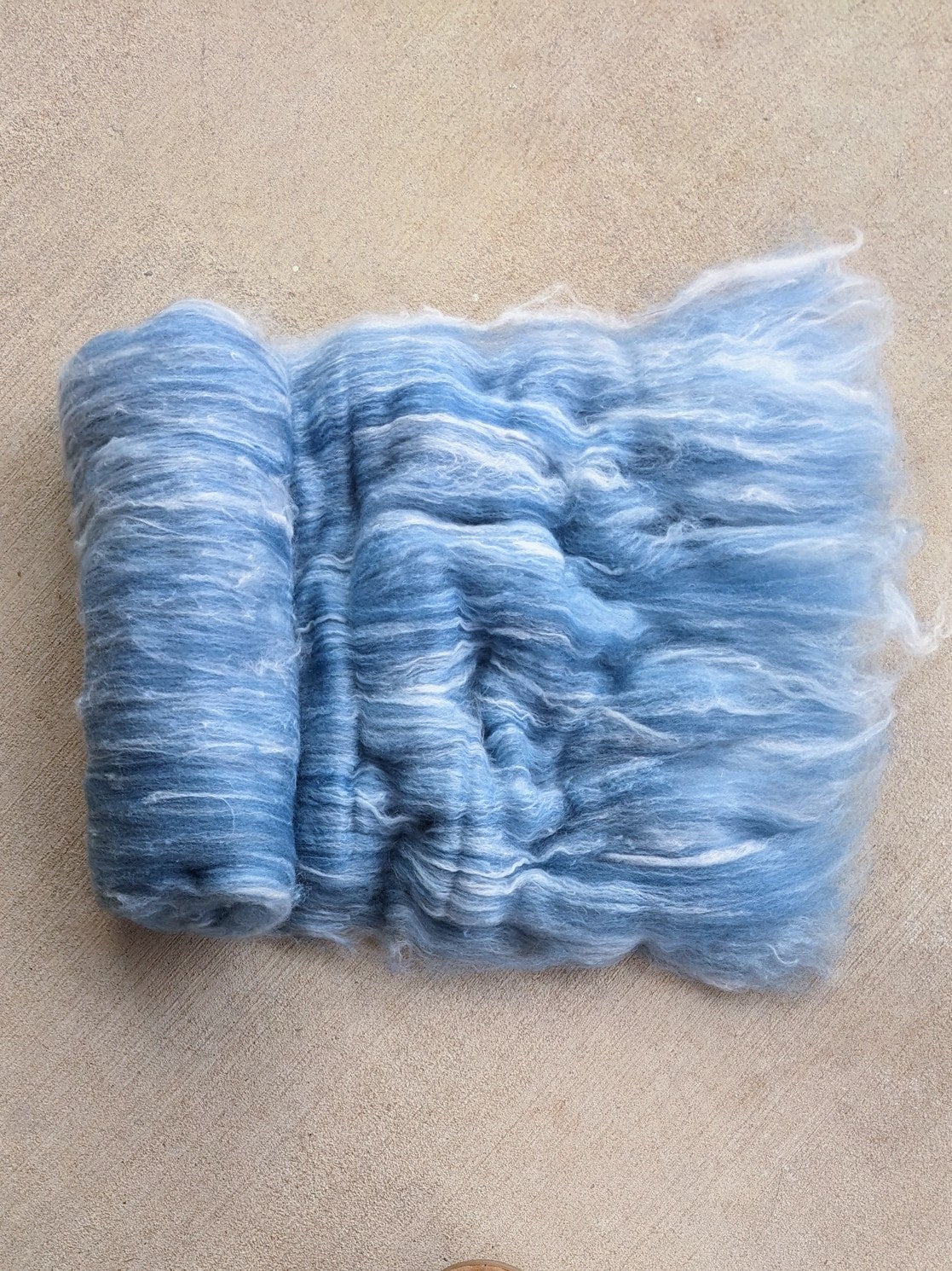 a light blue hand spinner batt made of a blend of cormo wool and angora rabbit fiber